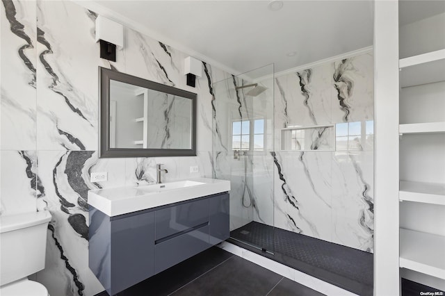 bathroom featuring a tile shower, tile patterned flooring, toilet, vanity, and tile walls