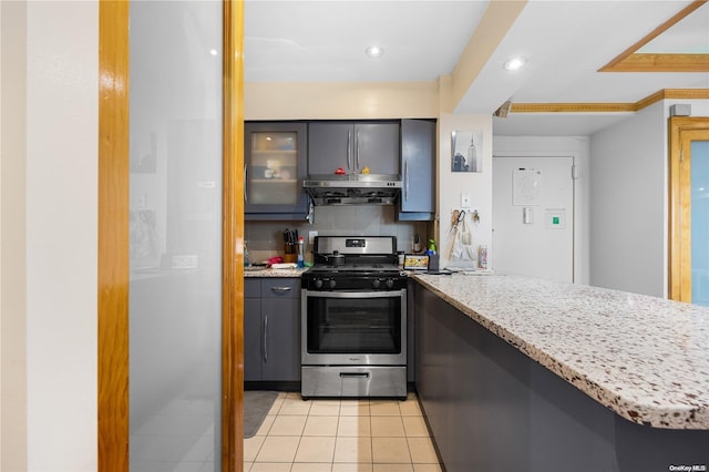 kitchen featuring kitchen peninsula, light tile patterned floors, range hood, and stainless steel range with gas stovetop