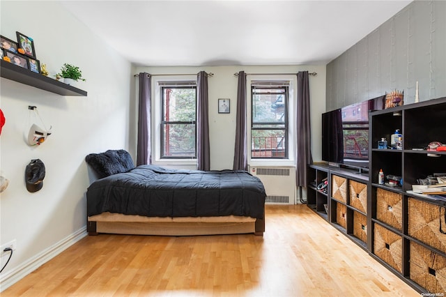 bedroom featuring hardwood / wood-style floors and radiator heating unit