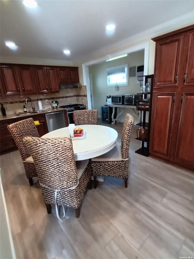 dining space with sink and light wood-type flooring