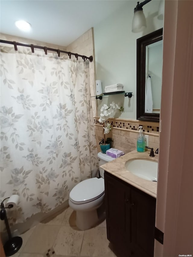 bathroom with a shower with curtain, tile patterned flooring, toilet, decorative backsplash, and vanity