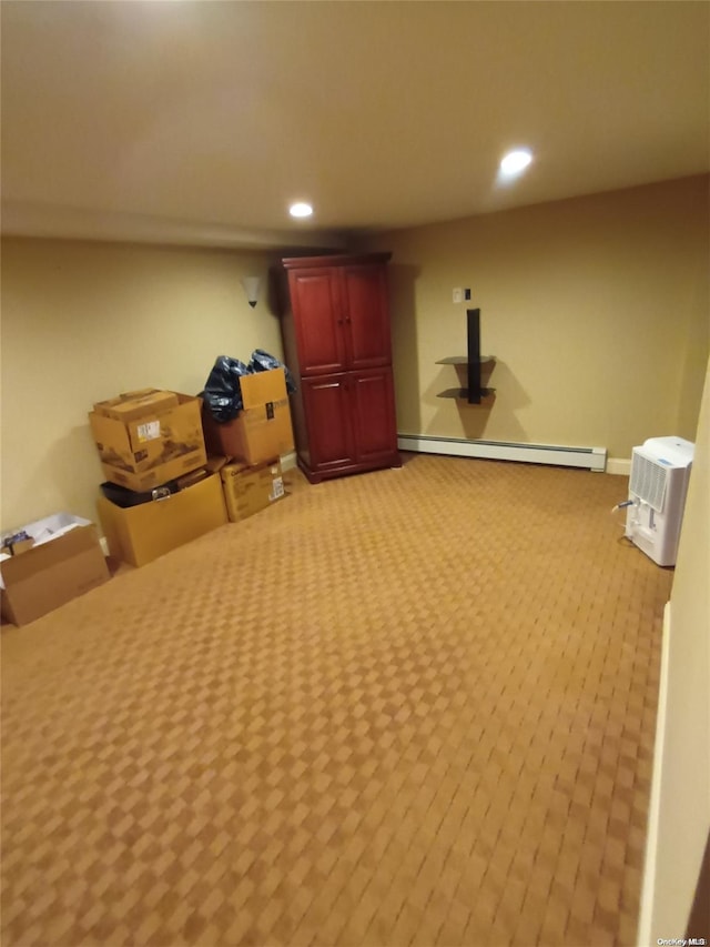 basement with light carpet and a baseboard heating unit