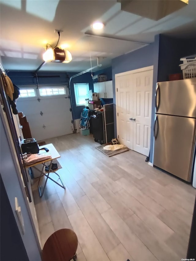 garage with a garage door opener and stainless steel refrigerator