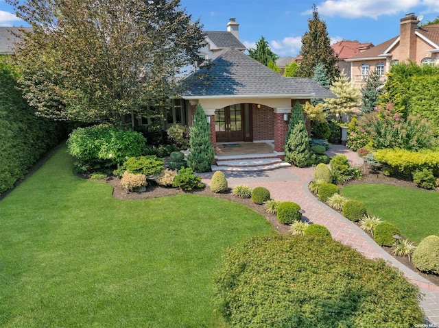 view of front facade featuring covered porch, french doors, and a front lawn