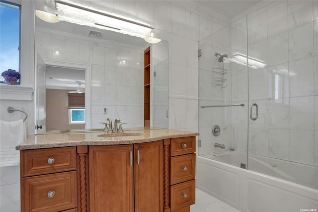 bathroom featuring vanity, combined bath / shower with glass door, crown molding, ceiling fan, and tile walls