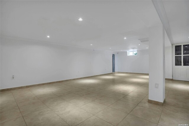 tiled empty room featuring crown molding