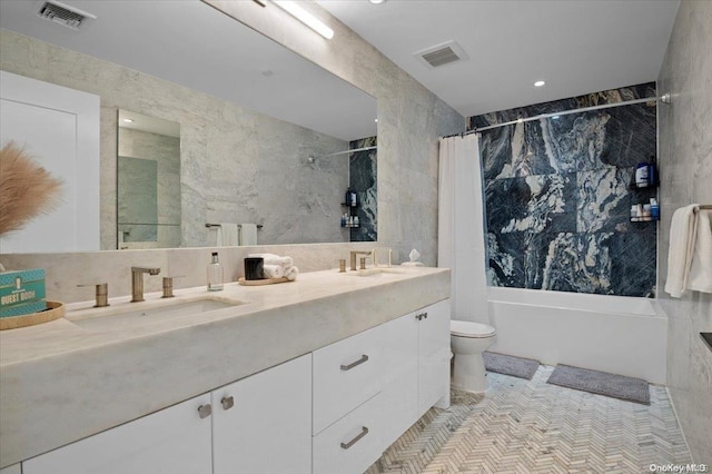 full bathroom with vanity, toilet, and tile walls