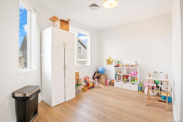 game room with light hardwood / wood-style flooring