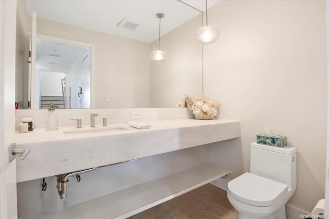 bathroom with sink, hardwood / wood-style floors, and toilet