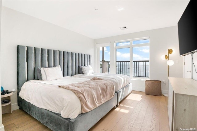 bedroom with light wood-type flooring and access to outside