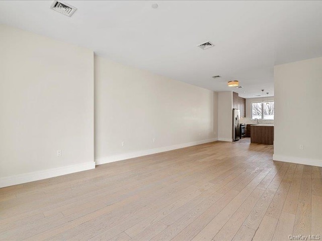 empty room with light hardwood / wood-style flooring