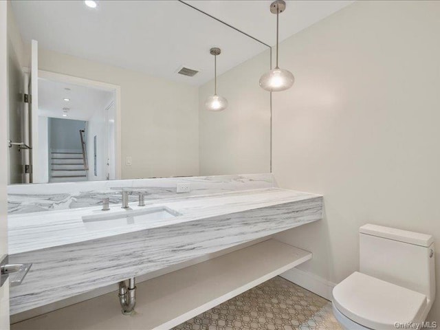 bathroom featuring sink, vaulted ceiling, and toilet