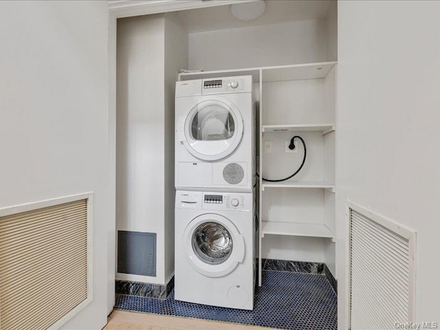 clothes washing area with stacked washer and clothes dryer