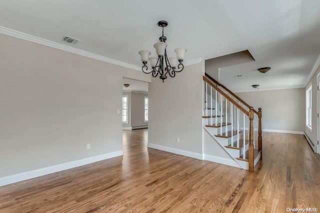 interior space with a chandelier, crown molding, hardwood / wood-style floors, and a baseboard radiator