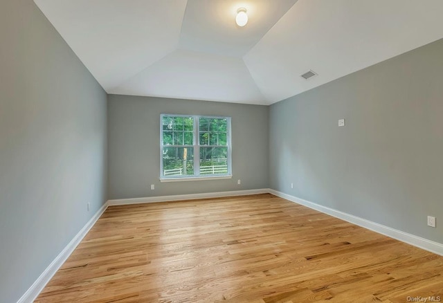 unfurnished room with lofted ceiling and light hardwood / wood-style flooring