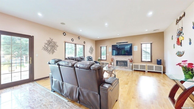 living room featuring a high end fireplace and light hardwood / wood-style floors