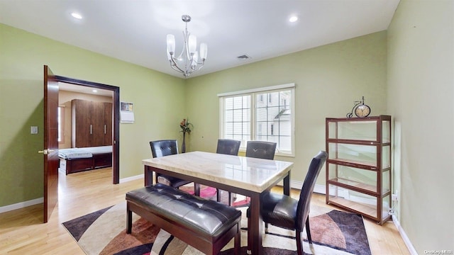 dining space with a notable chandelier and light hardwood / wood-style flooring