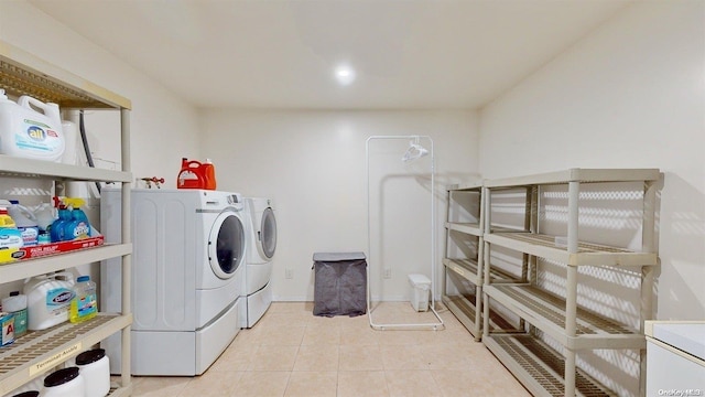 laundry area featuring separate washer and dryer and light tile patterned floors