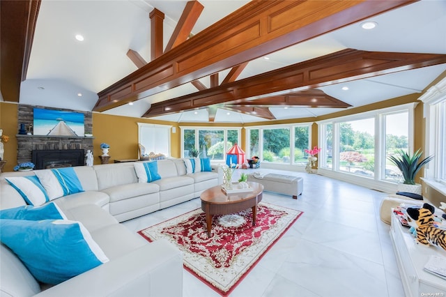 living room with lofted ceiling with beams, a stone fireplace, and a healthy amount of sunlight