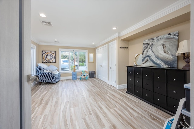 sitting room with light wood-type flooring and ornamental molding