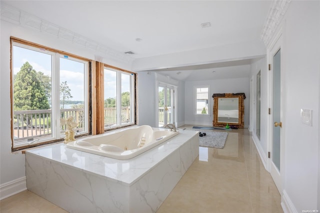 bathroom featuring tiled bath, tile patterned floors, and a healthy amount of sunlight