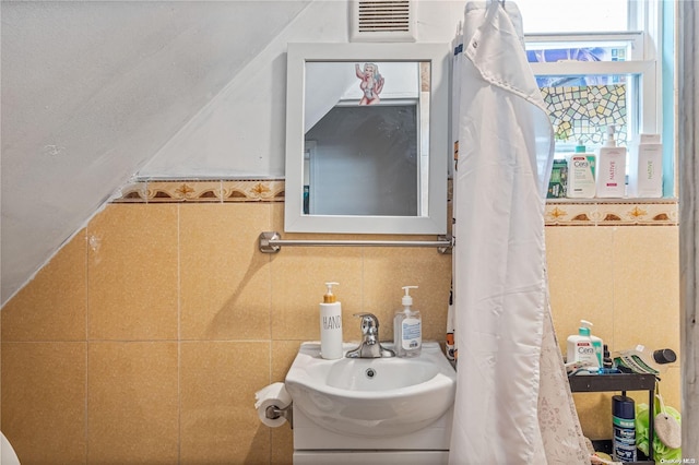 bathroom featuring vanity and tile walls