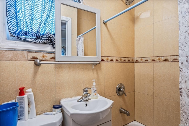 full bathroom with tile walls and sink