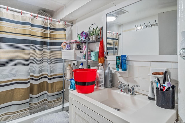 bathroom with vanity and tasteful backsplash