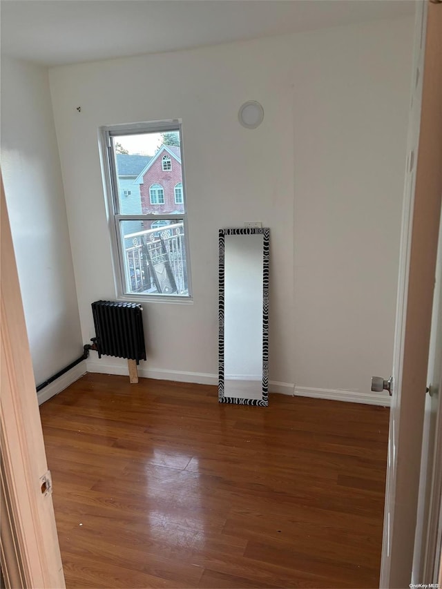 empty room featuring hardwood / wood-style floors and radiator