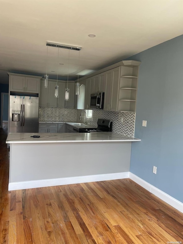 kitchen featuring pendant lighting, gray cabinetry, dark hardwood / wood-style floors, appliances with stainless steel finishes, and kitchen peninsula