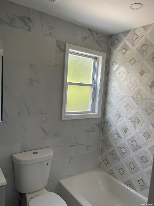 bathroom with vanity, toilet, and tile walls