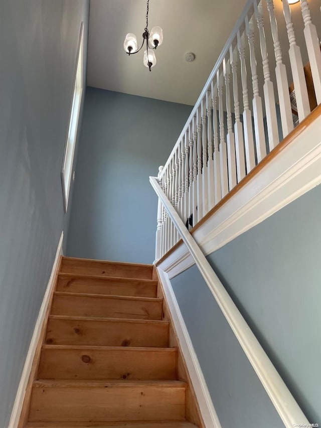 staircase featuring an inviting chandelier