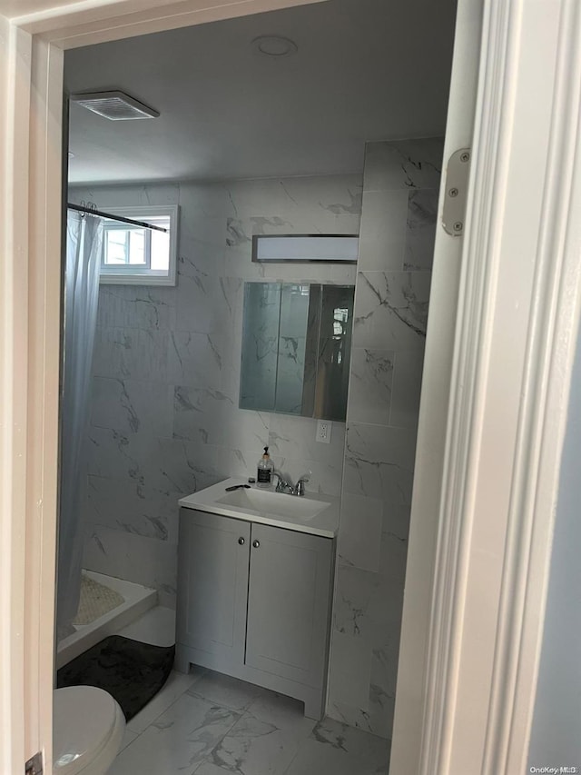 bathroom featuring a shower with curtain, vanity, toilet, and tile walls