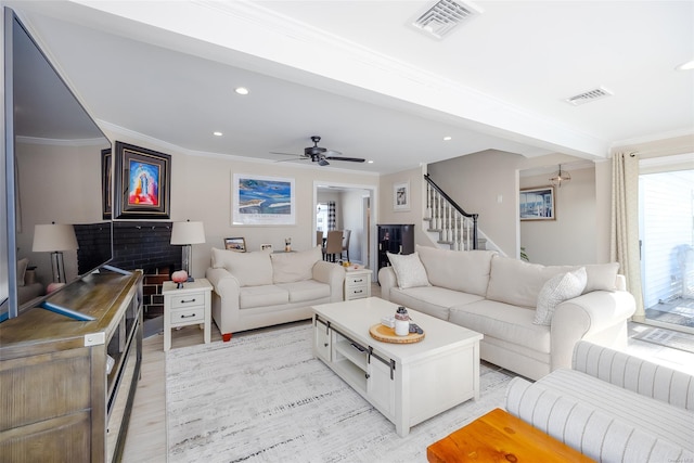 living room featuring crown molding, ceiling fan, and light wood-type flooring