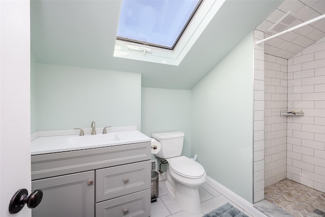 bathroom featuring toilet, vanity, lofted ceiling with skylight, and a tile shower