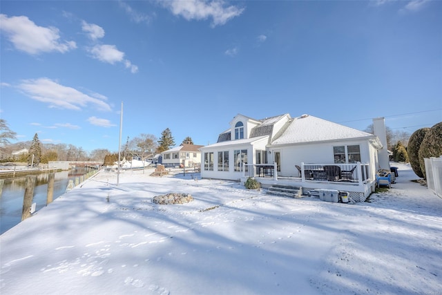 snow covered rear of property featuring a deck