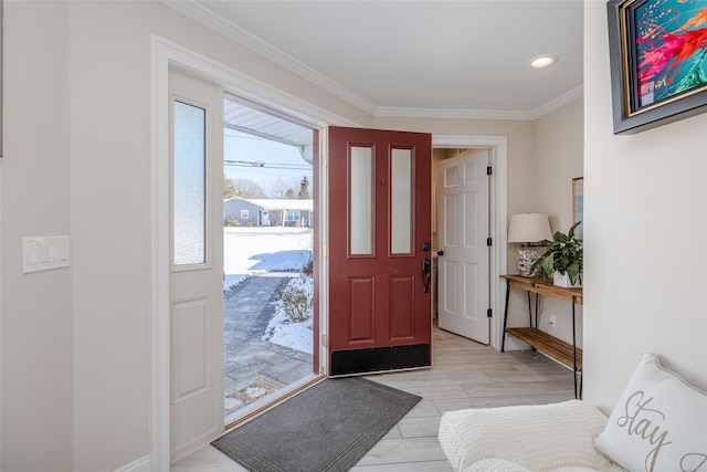 foyer entrance with ornamental molding, light hardwood / wood-style flooring, and a wealth of natural light