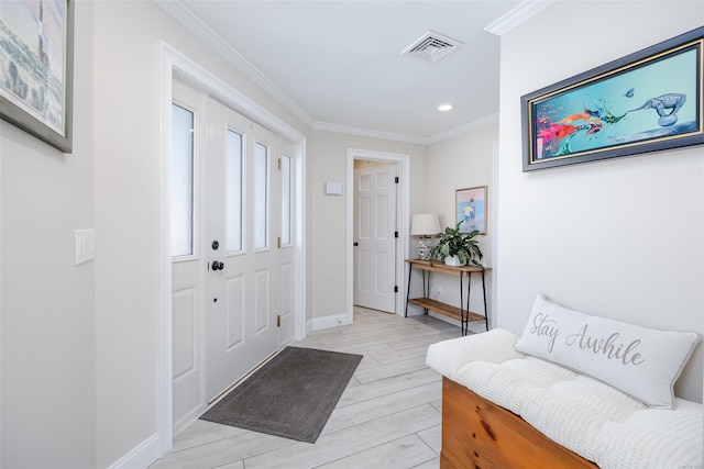 foyer entrance with ornamental molding and light wood-type flooring