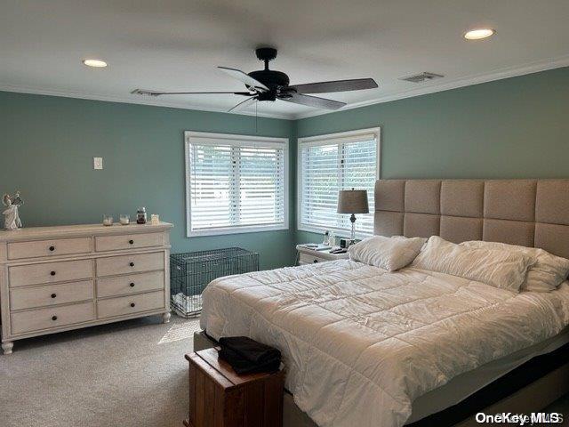 carpeted bedroom featuring crown molding and ceiling fan