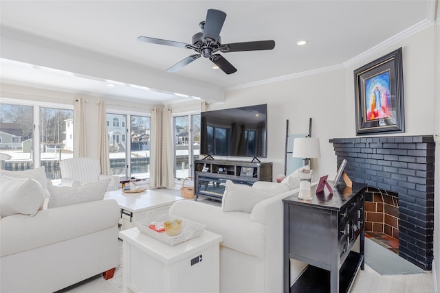 living room featuring crown molding, ceiling fan, and a brick fireplace