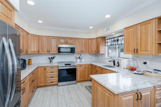 kitchen with tasteful backsplash, appliances with stainless steel finishes, kitchen peninsula, and sink