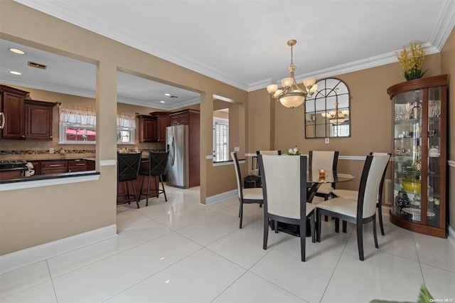 dining room featuring light tile patterned floors, crown molding, and an inviting chandelier