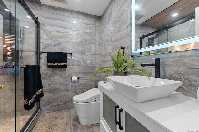 bathroom featuring vanity, a shower with door, hardwood / wood-style flooring, toilet, and tile walls