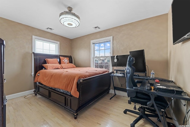 bedroom featuring light hardwood / wood-style floors and multiple windows