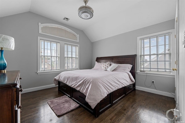 bedroom featuring dark hardwood / wood-style flooring, lofted ceiling, and multiple windows