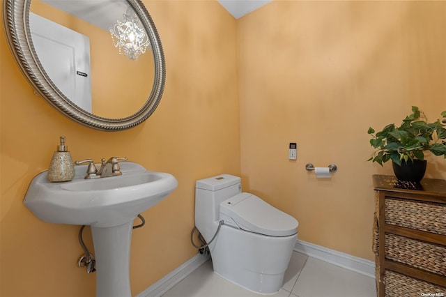 bathroom with tile patterned flooring, toilet, and a notable chandelier