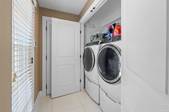 clothes washing area with washer and dryer and light tile patterned floors