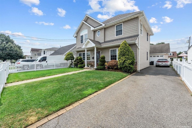 view of front of house with a garage, an outbuilding, and a front yard