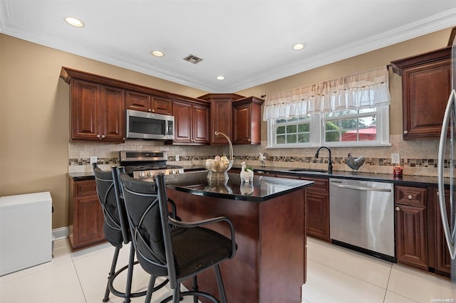 kitchen with backsplash, a center island, light tile patterned floors, and stainless steel appliances