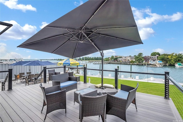 deck with a water view and a yard